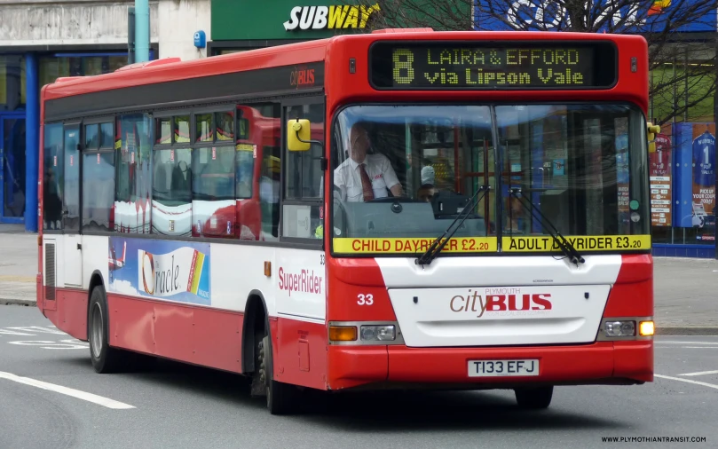 a passenger bus travels down the road in the city