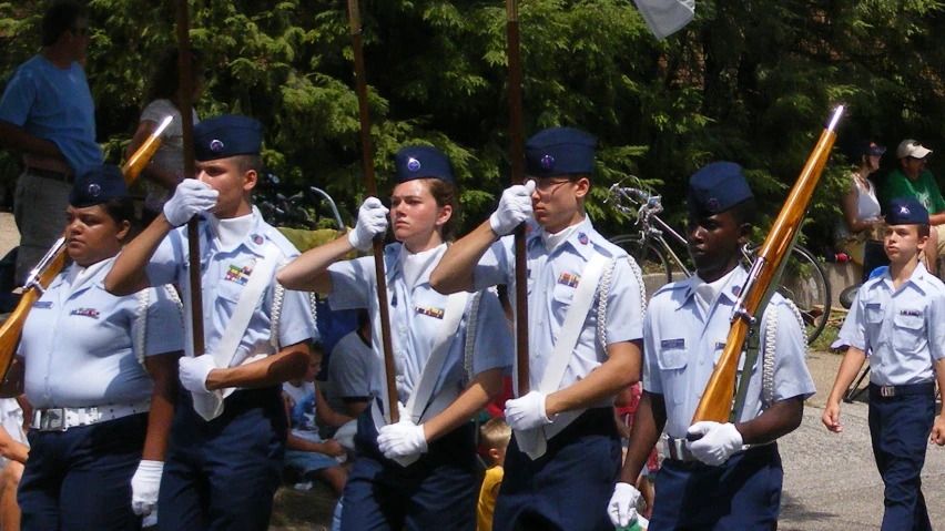 some women in uniforms are walking with their sticks