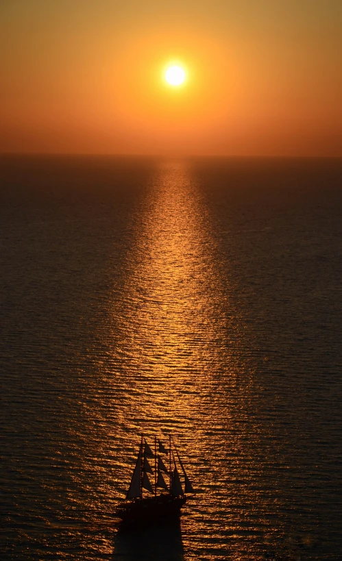 a boat is sailing on the ocean at sunset