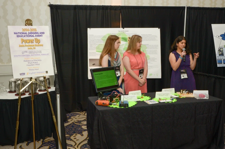 two ladies stand at a table with other information