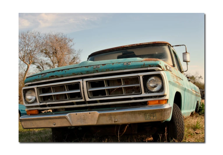 an old truck parked in a grassy area
