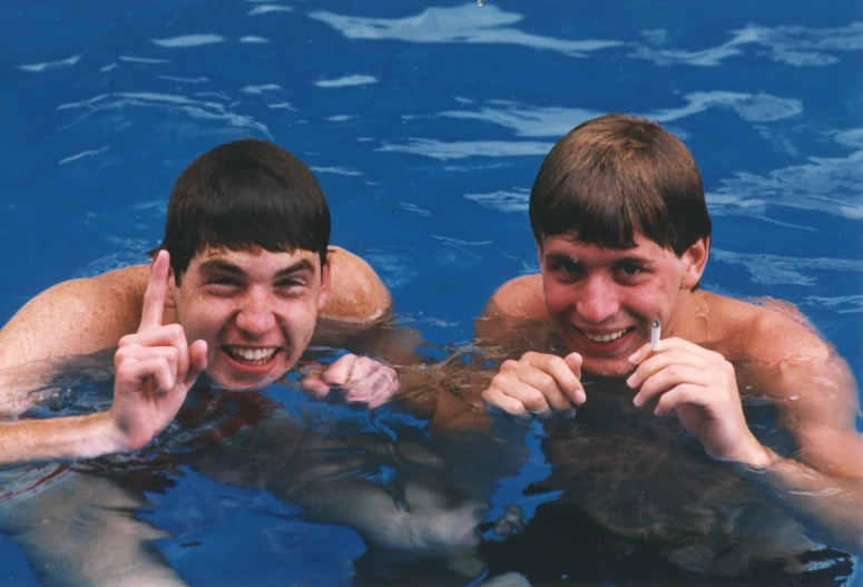 two people swimming together in a pool posing for a po