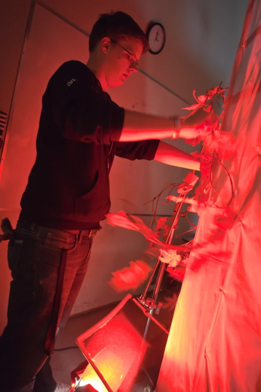 a man is lighting red and looking through a window