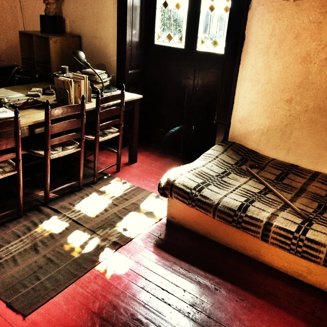 a bed room with a neatly made bed and a wooden table