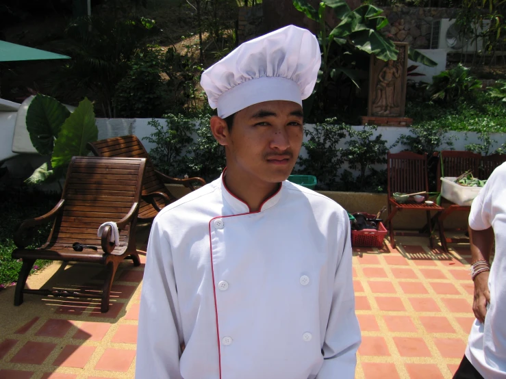 a man in a chef's uniform is standing outside