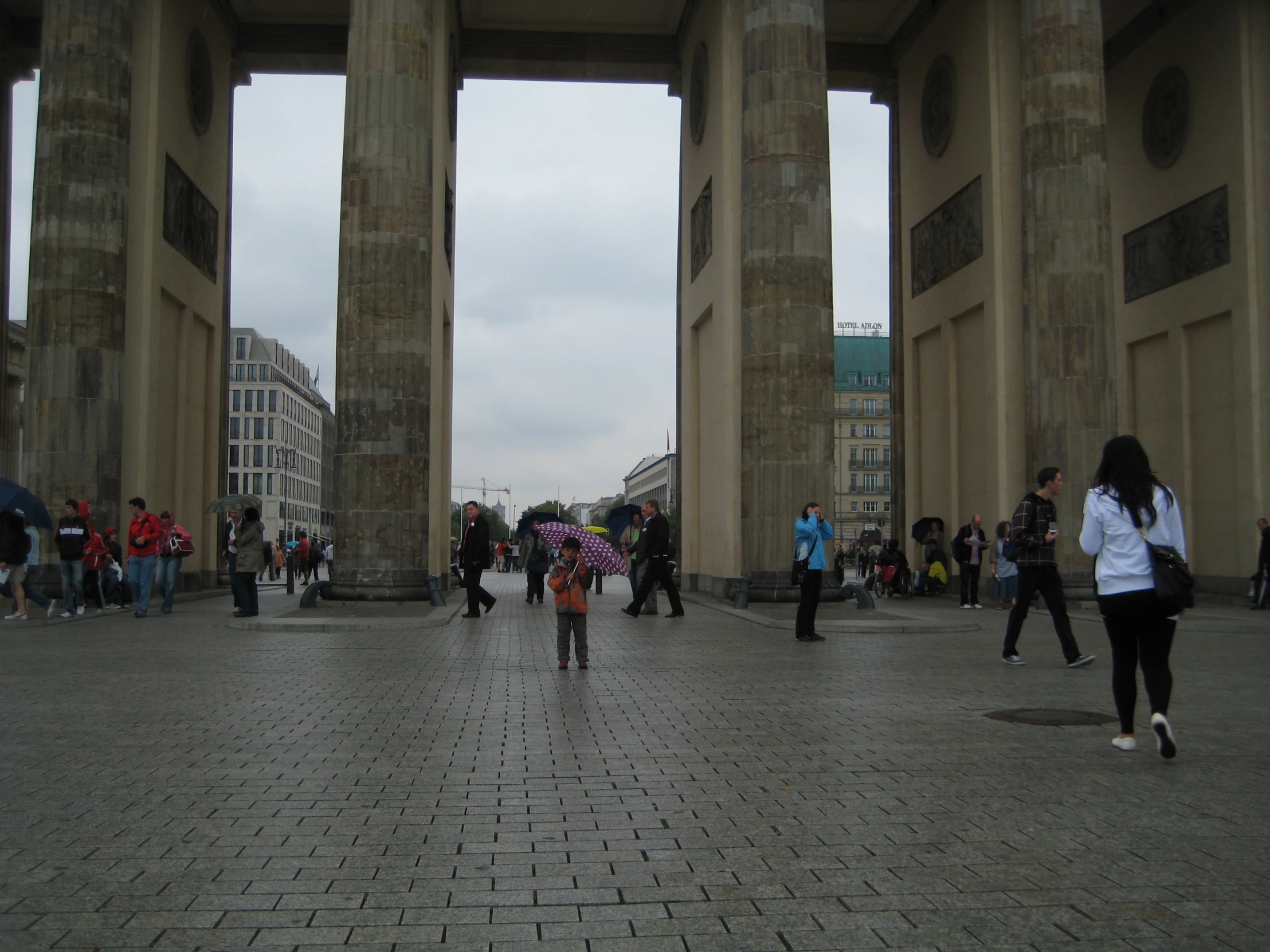 people walking around a square with stone pillars