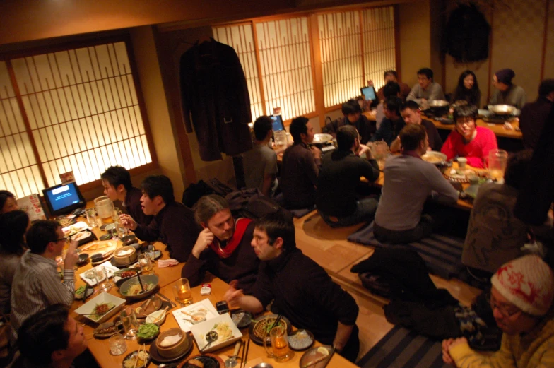 a group of people sitting at tables eating food