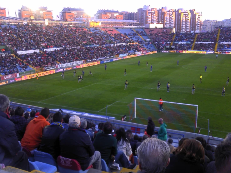 a large stadium full of people sitting and standing