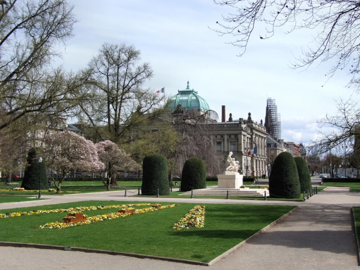 a beautiful building with tall trees and grass