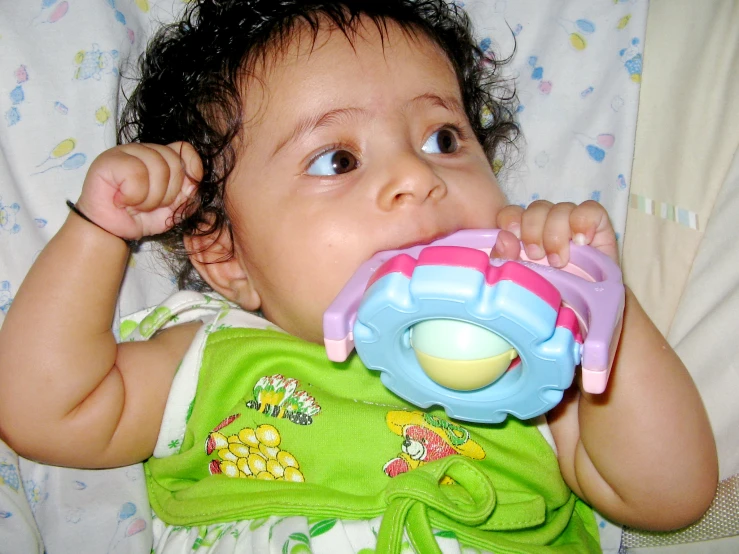 an infant chewing on a baby teeth toy