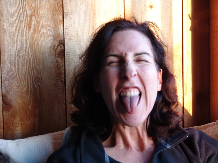 a woman is sticking her tongue out and yawning