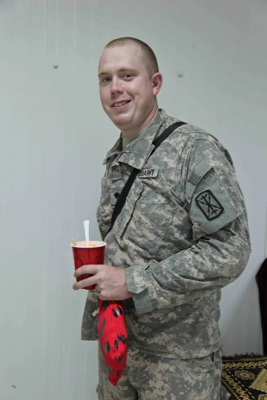 a male in uniform is holding a drink