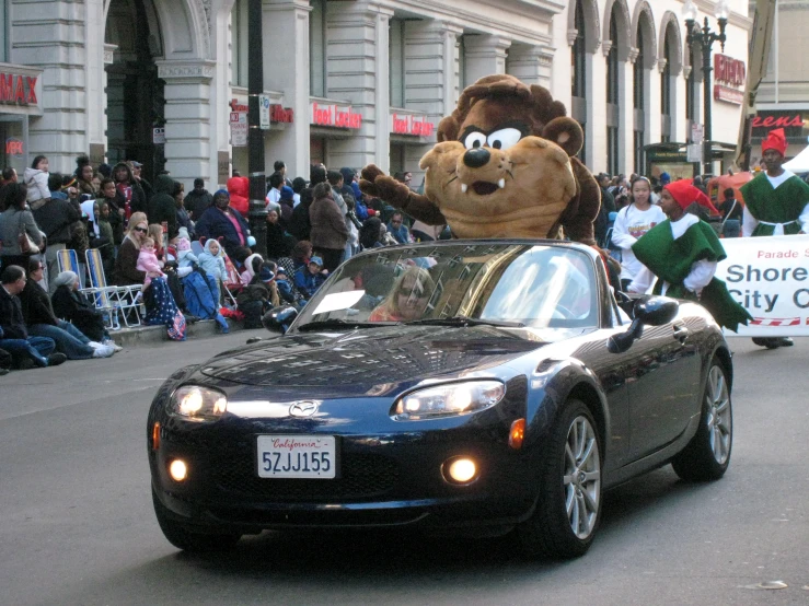 the car is being driven with a large stuffed animal in the back