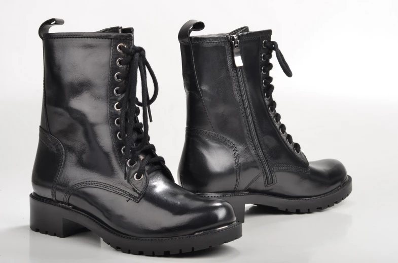 two black combat boots with laces and zippers on the upper part