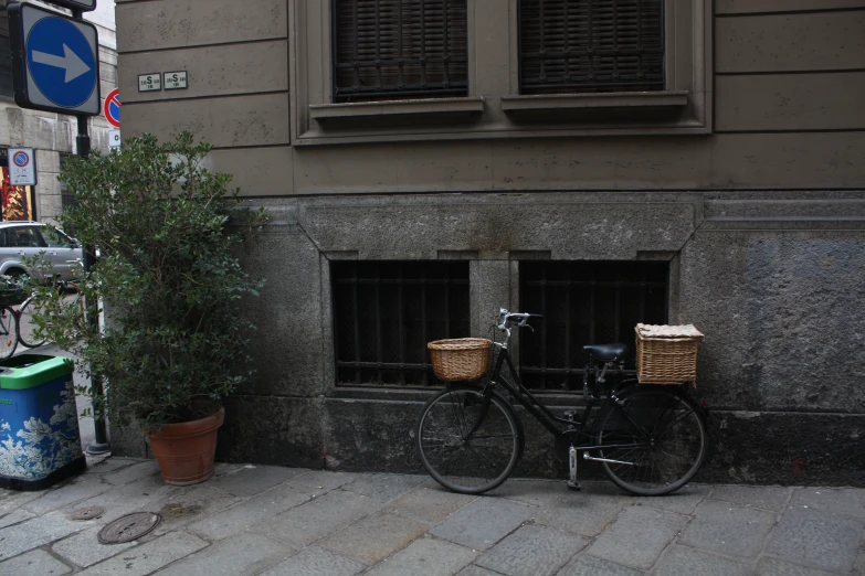 a bicycle parked on a city sidewalk next to a pole