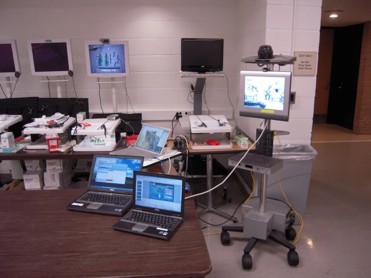 there are some laptops and desktop computer monitors in a room