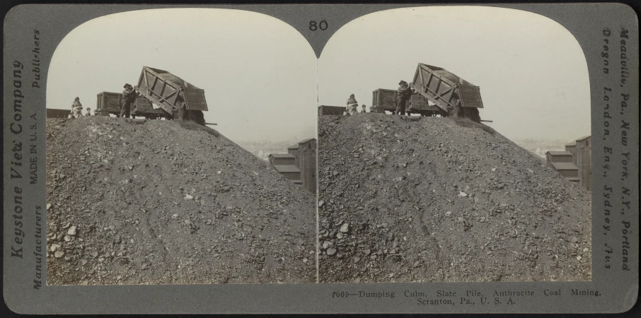 old timey pograph of two coal trucks