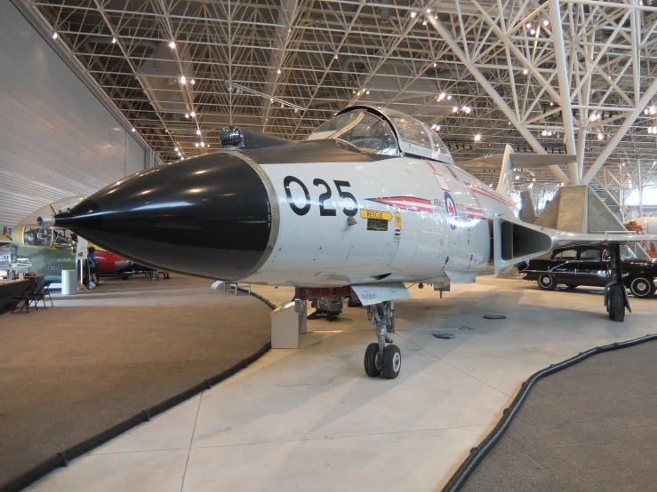 an older fighter jet sits in the hangar