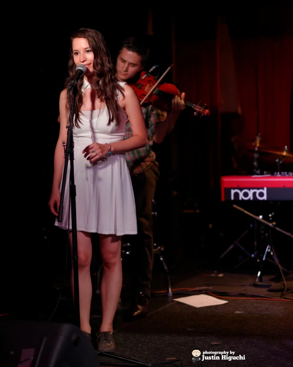 a woman in a white dress holding a guitar