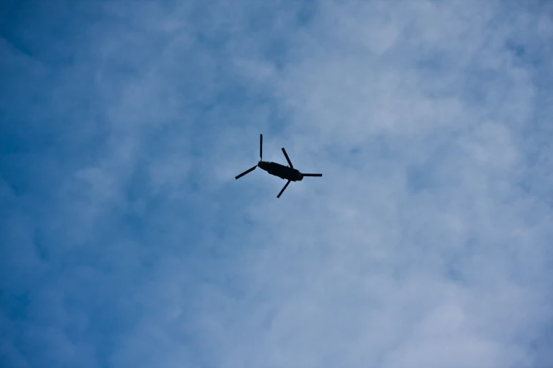 an air plane flies in the sky against a blue sky