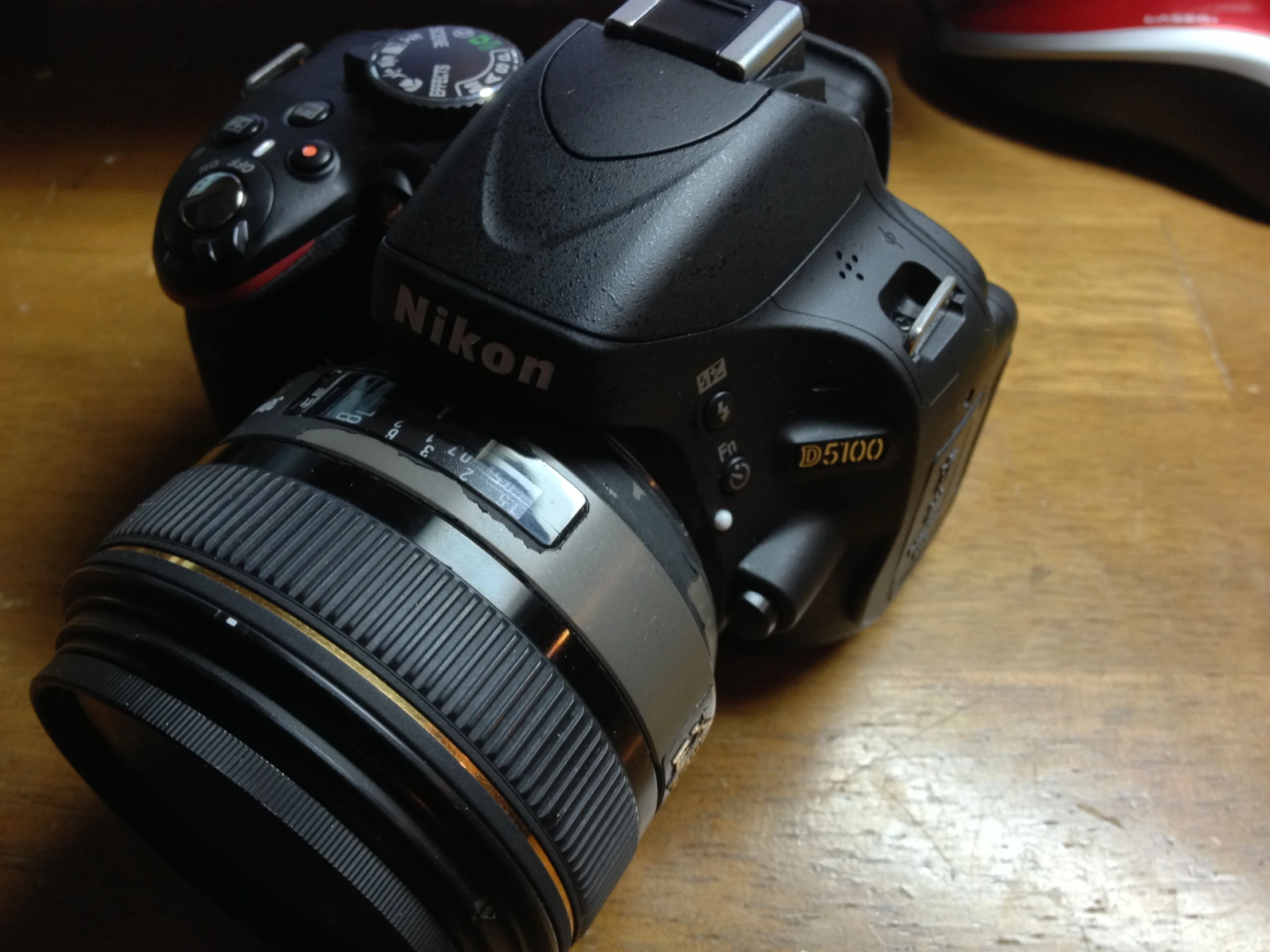 a camera on a wooden table with a meter