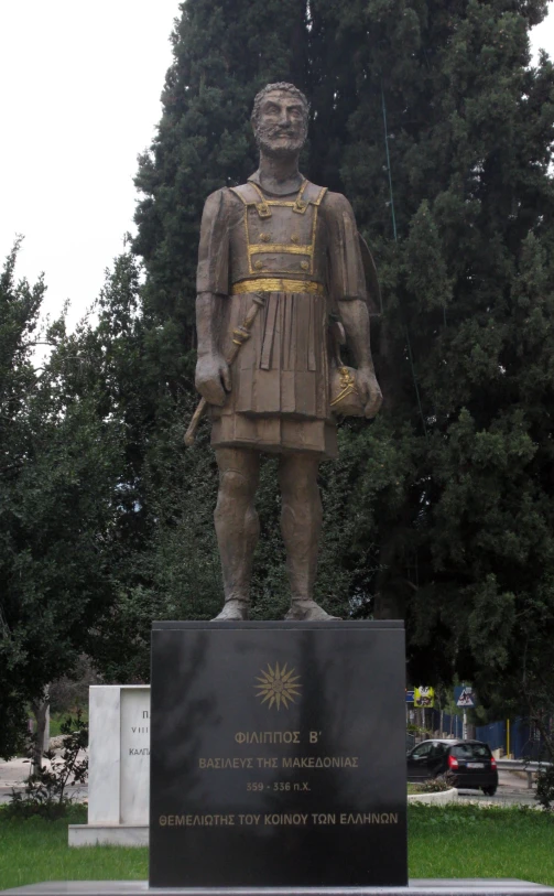 a statue of a man standing next to trees