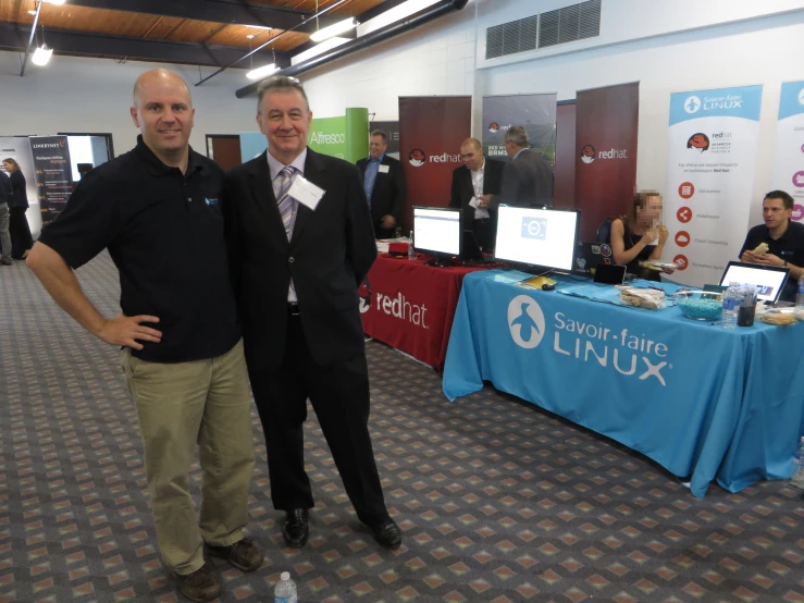 two men standing together in a room full of tables