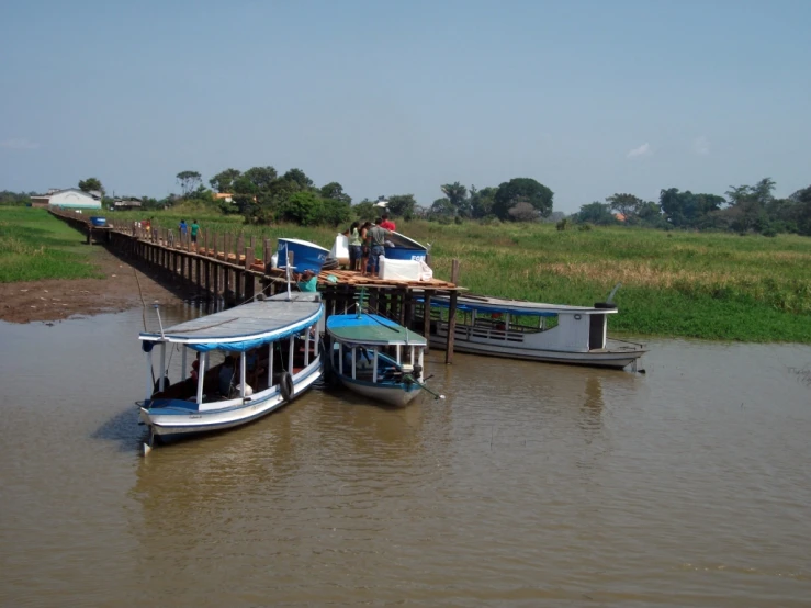 boats on a river at a jetty with wooden pier