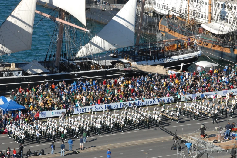 a parade with many people in uniforms watching a parade