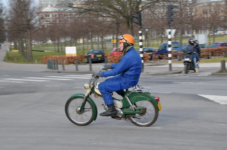 a man riding on the back of a motorcycle down a street