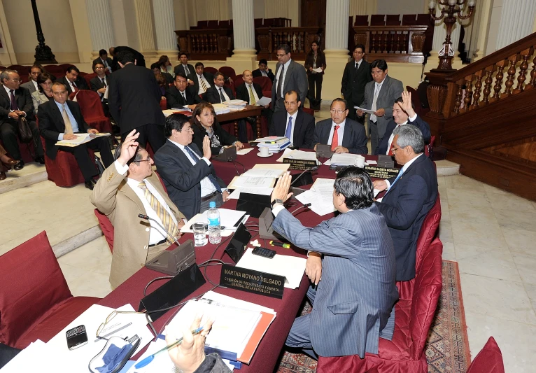 several people sit at their desks in the middle of a room