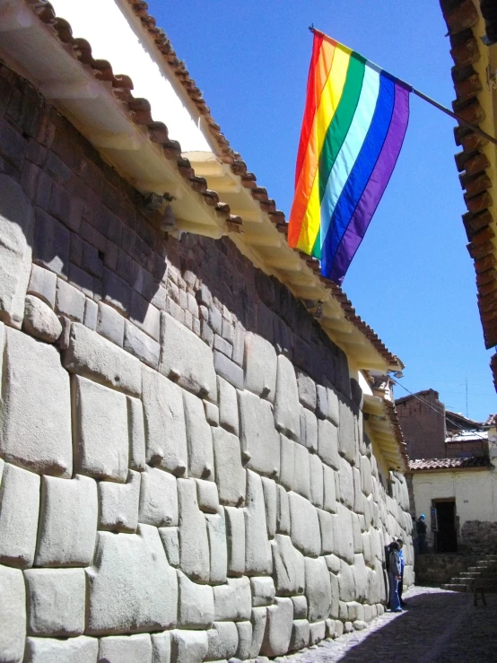 a rainbow flag hanging over the wall of an old incaana