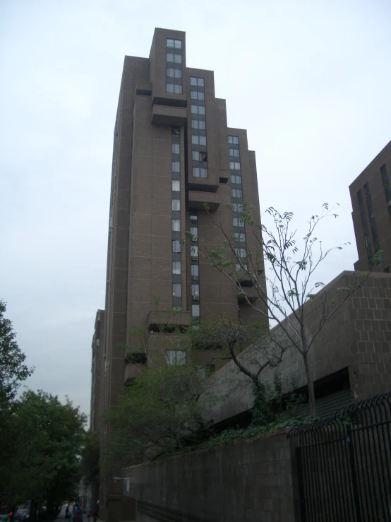 a tall building with several windows next to a metal fence