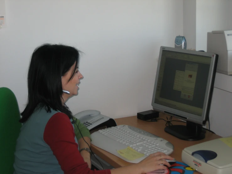 a woman sitting at a desk using a computer