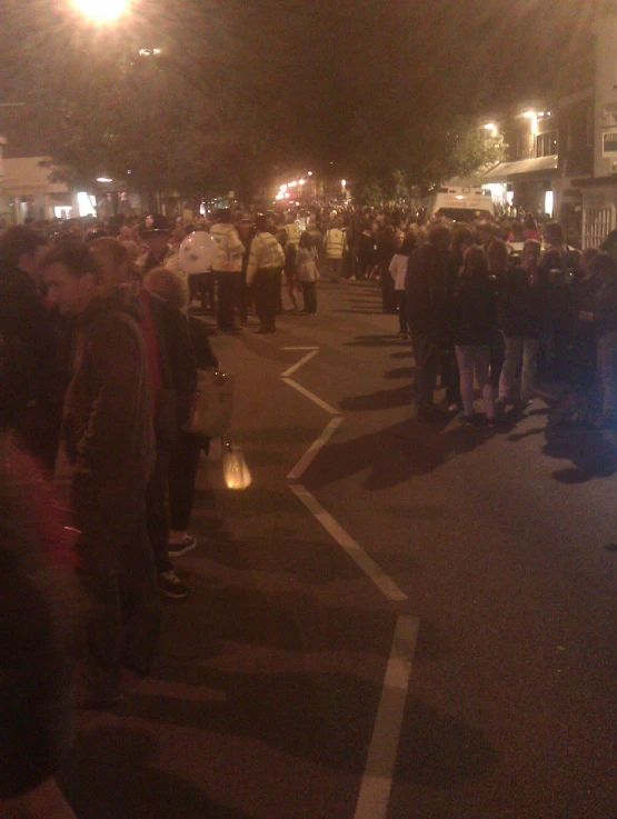 a crowd is gathered in the street on a busy night