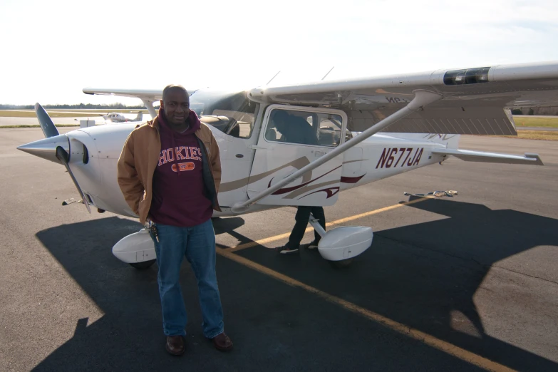 there is a man standing next to a plane