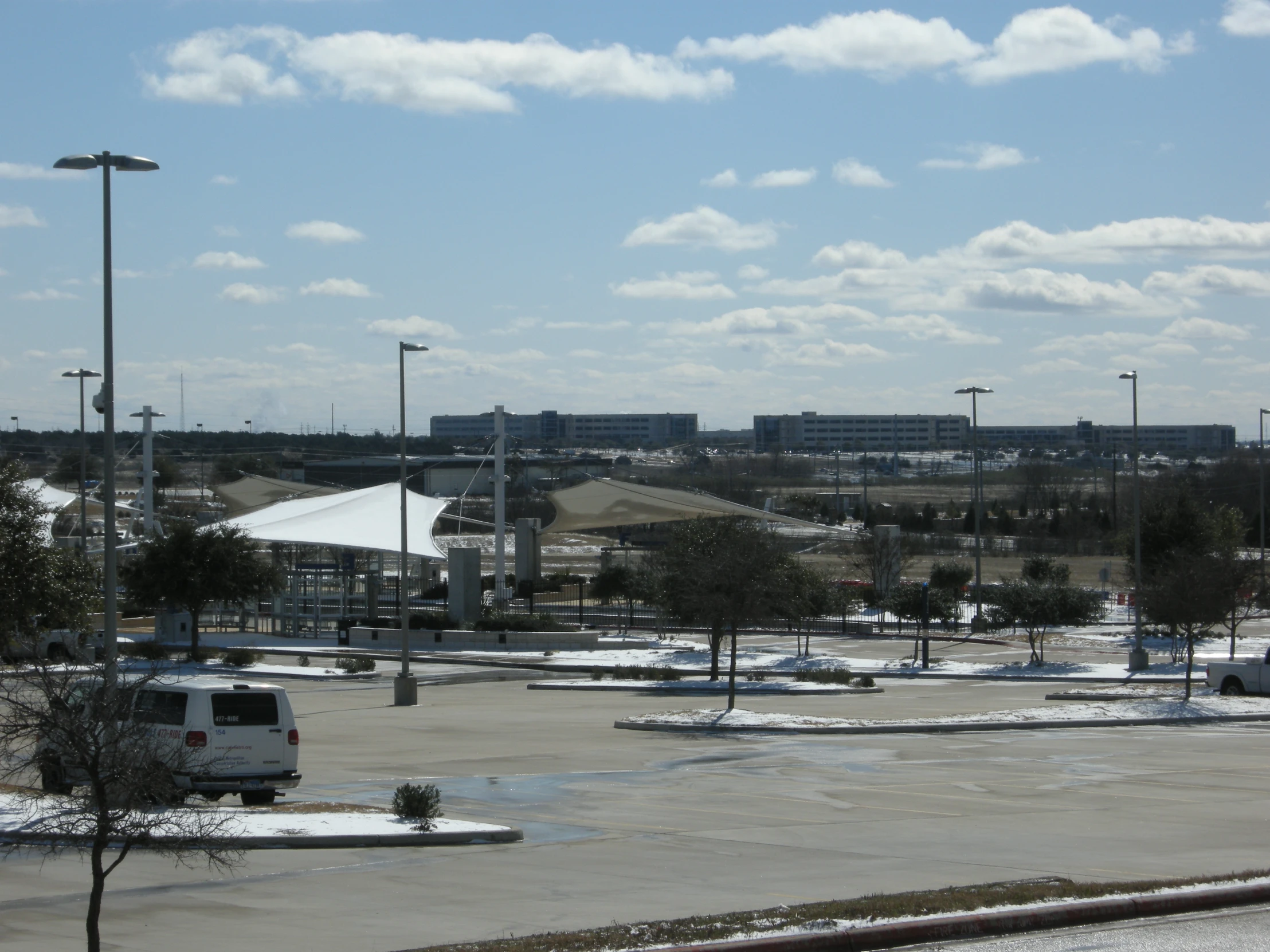 a parking lot with cars in the distance and a blue sky