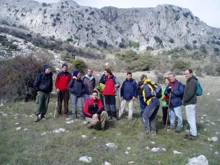 a group of people wearing backpacks standing in a field