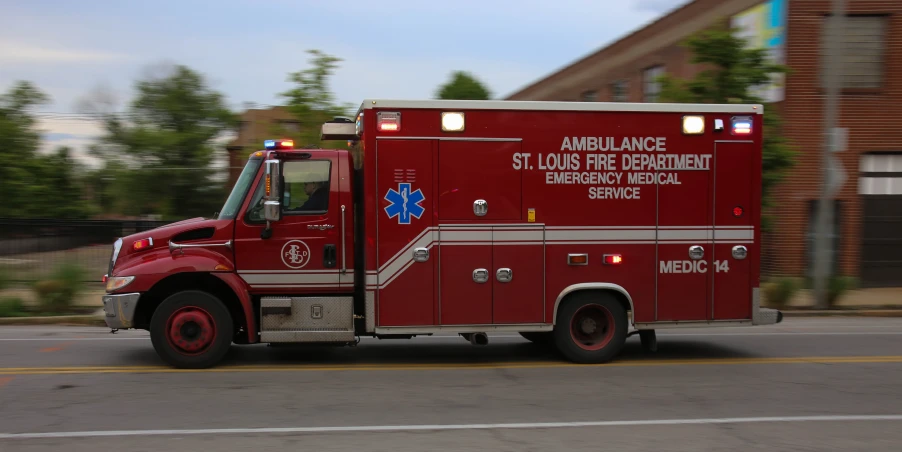 a large red ambulance parked on the side of a road