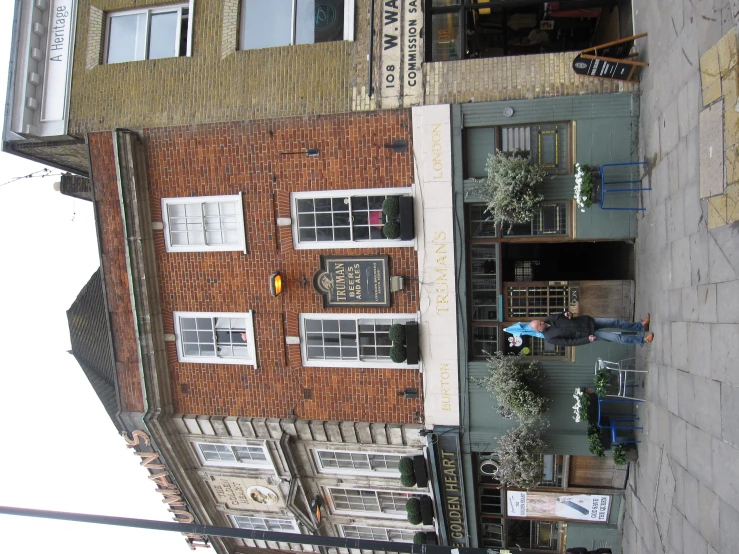 a brick building in the city with flowers growing in it