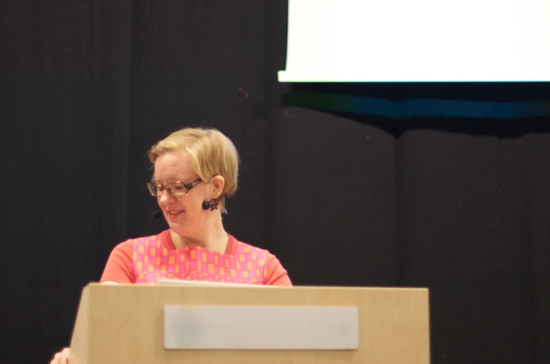 a woman is standing behind a large podium