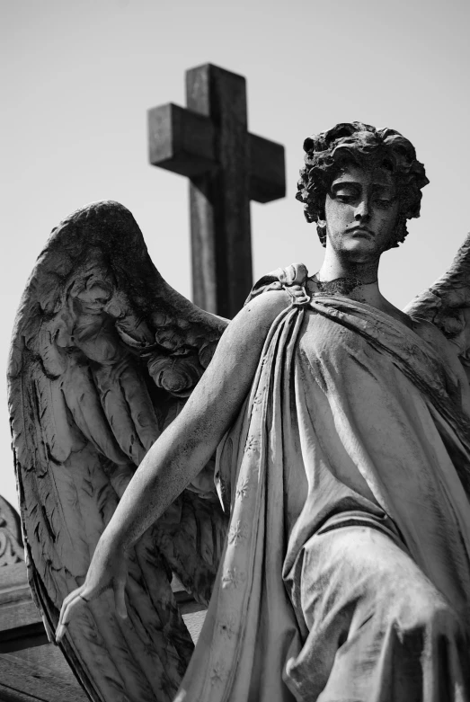 an angel with wings standing in front of a cross