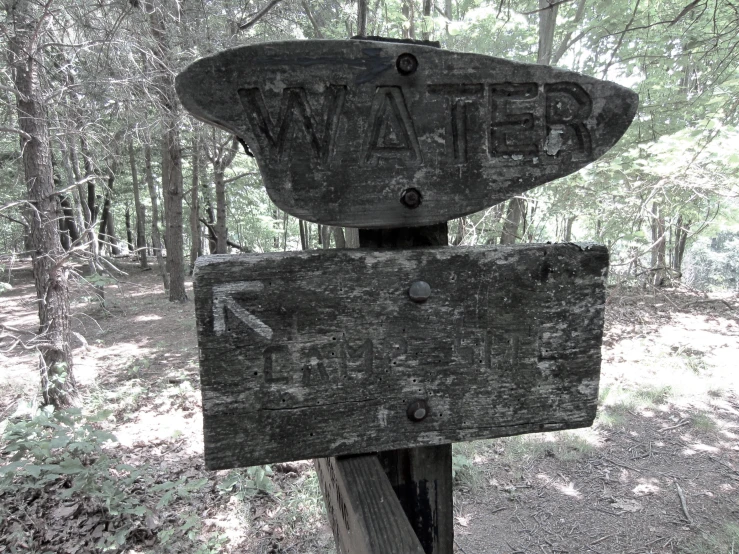 two wooden signs posted in a wooded area