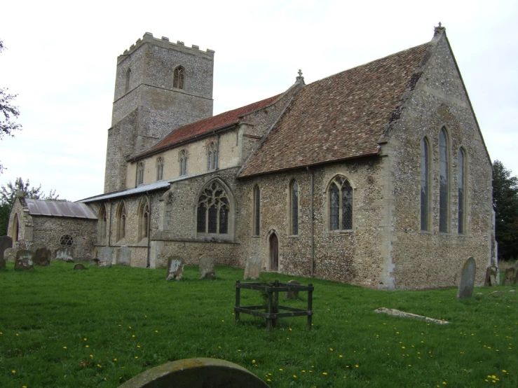 old building near graveyard with green grass and trees