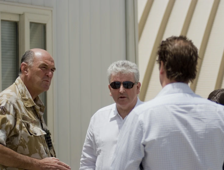 two men and a man in white shirt with sunglasses