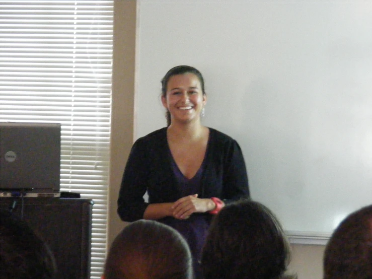 a woman standing in front of a whiteboard holding a toothbrush