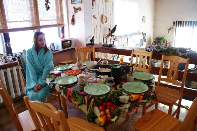 woman seated on chair in residential kitchen with table and vegetables