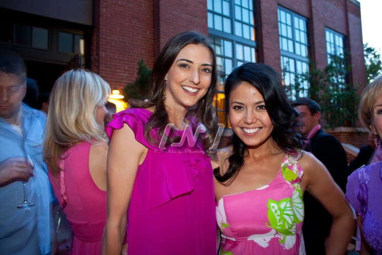 two women are posing for a picture while dressed in dresses