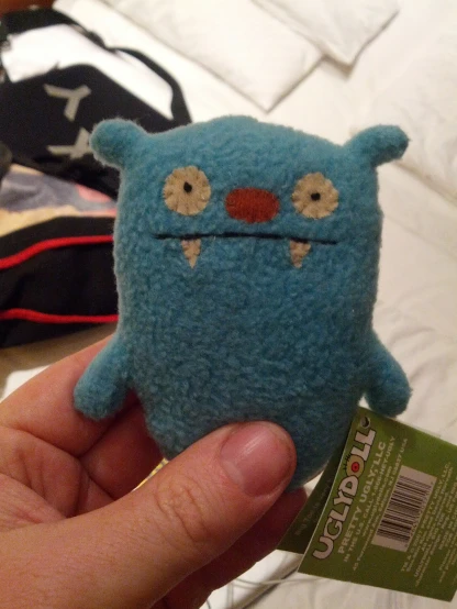 a person is holding a tiny monster doll