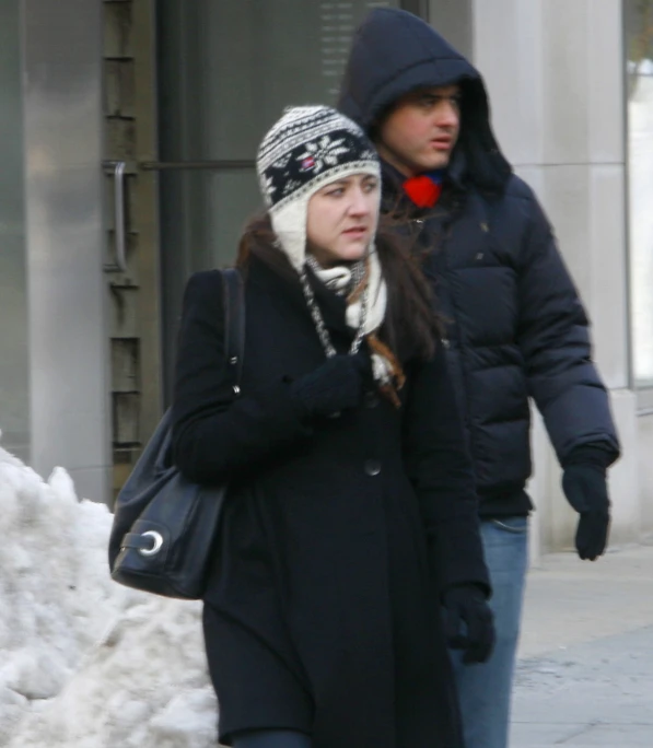 the man and woman are walking outside in winter clothes